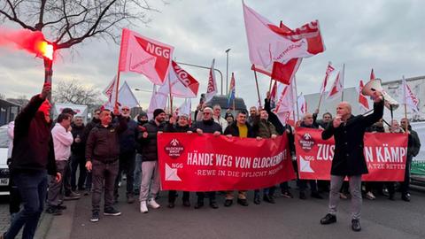 Mitarbeiter demonstrieren vor dem Werk mit Fackel, Megaphon und Transparenten