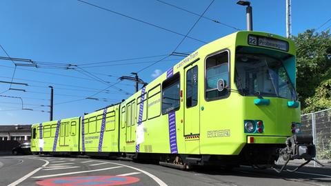 Eine grüne Straßenbahn auf den Schienen