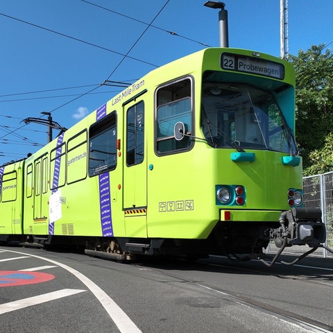 Eine grüne Straßenbahn auf den Schienen