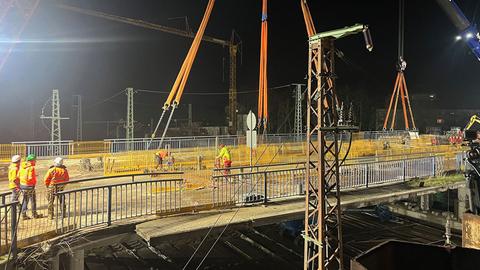 Mitarbeiter stehen auf der Brücke in Hanau, die weiter abgerissen werden soll.