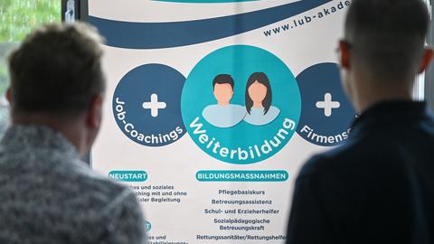 Zwei Menschen informieren sich in einem Jobcenter über Beratungsangebote