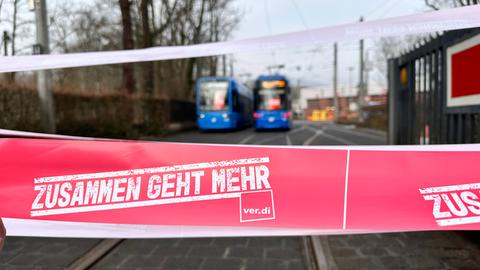 Verdi-Schriftzug "Zusammen geht mehr", im Hintergrund stehende Straßenbahnen