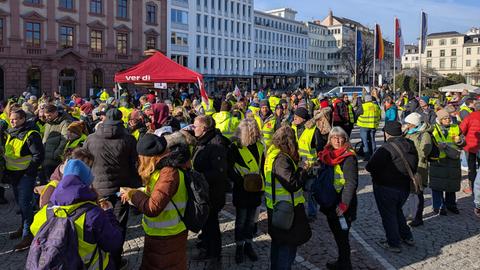 Viele Menschen in gelben Warnwesten stehen auf dem Platz vor dem Bad Homburger Kurhaus, dazwischen ein Zeltstand mit der Aufschrift „Verdi“