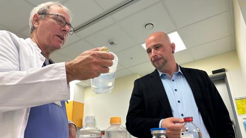  Christoph Lang (Asklepios Kliniken Schwalm-Eder) und Andreas Hettel (Stellvertretender Ärztlicher Direktor Klinikum Schwalmstadt) halten Flaschen und Beutel mit Kochsalzlösung in den Händen