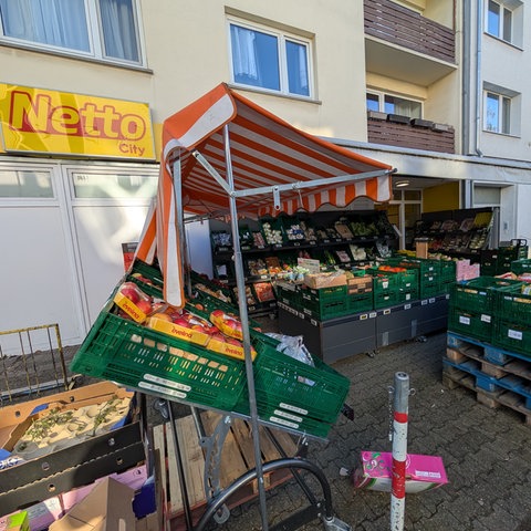 Blick auf die Fassade der Netto-Filiale in Darmstadt. Davor stehen Obst und Gemüse in Kisten. 