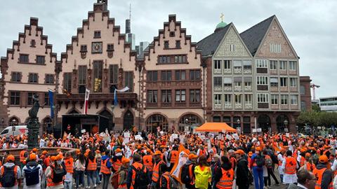 Menschen in orangener Kleidung auf dem Römerberg