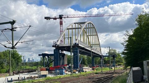 Bahnbrücke am Bahnhof Frankfurt-Stadion für die Regionaltangente West, Brücke steht aufgebockt und bereit zum Einschub neben den bestehenden Gleisen