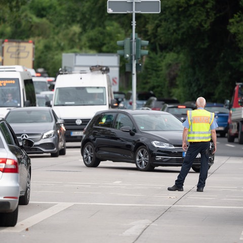 Ein Verkehrspolizist regelt den stockenden Verkehr an einem Zubringer zur A66 in Wiesbaden