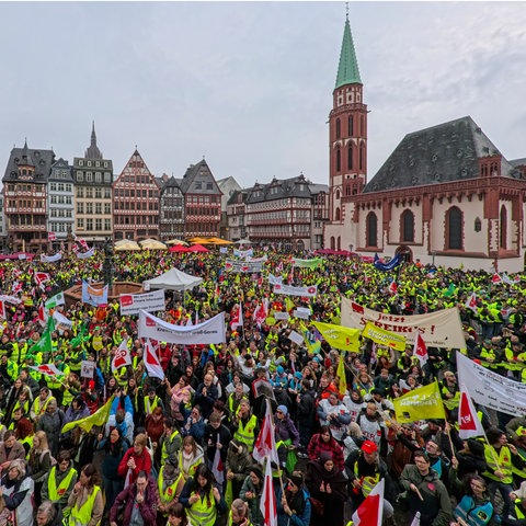 Hunderte Teilnehmende - viele mit gelben Warnwesten - mit Verdi-Fahnen und Transparenten einer Verdi-Kundgebung auf dem Römerberg in Frankfurt