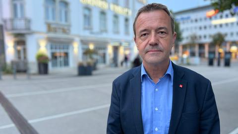 Der VW-Betriebsratsvorsitzernde Carsten Büchling steht in einem blauen Anzug am Bahnhof Wilhelmshöhe in Kassel.