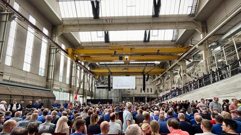 Mitarbeiter von VW sitzen in einem Saal. 