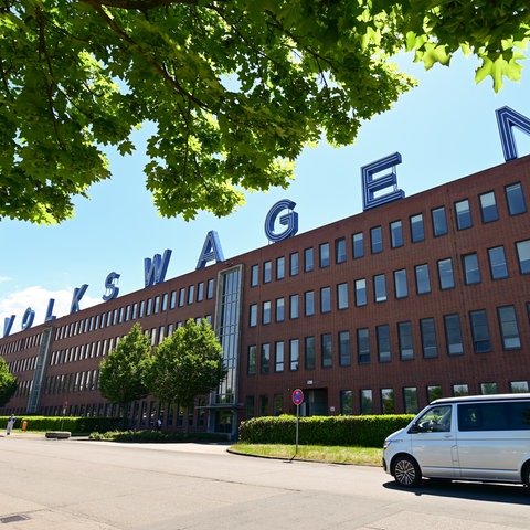 VW-Werk in Baunatal von außen, Backsteinbau mit blauem "Volkswagen"-Schriftzug auf dem Dach