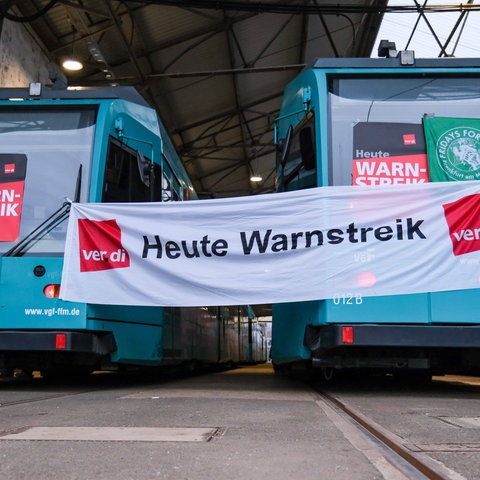 Zwischen zwei U-Bahnen in Frankfurt ist ein Transparent mit der Aufschrift"Heute Warnstreik" gespannt. 