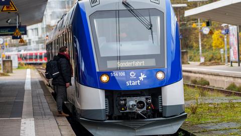 Ein Bahnmitarbeiter unterhält sich mit dem Triebwagenführer eines Alstom-Wasserstoffzugs im Bahnhof Bad Homburg.