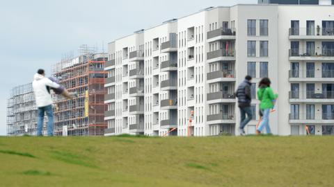 Spaziergänger sind in einem Neubaugebiet in Frankfurt unterwegs.